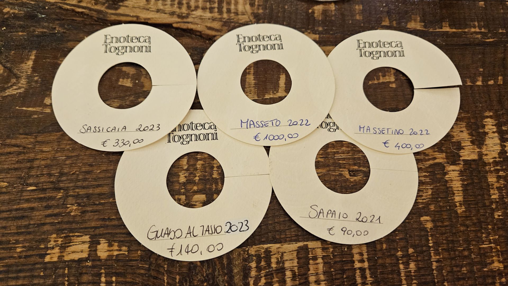 Az Enoteca Tognoni kézzel írt palackcédulái az árakkal